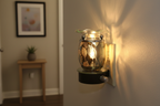 Silver leaf wall plug-in oil burner in small space hallway glowing warm golden light